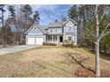 Traditional two-story home with an attached two-car garage, porch, and manicured lawn, nestled among mature trees at 3541 Rugby Rd, Durham, NC 27707