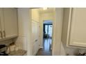 Clean and well-lit hallway with white walls and a view into the dining area at 49 W Copenhaver Dr, Clayton, NC 27527