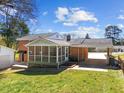 Backyard view with screened-in porch, brick exterior, attached carport at 5108 Melbourne Rd, Raleigh, NC 27606