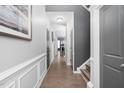 Inviting hallway featuring hardwood floors, gray paneled walls, and access to the staircase at 5433 Jessip St, Morrisville, NC 27560