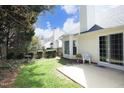 Backyard featuring a sliding glass door leading to a concrete patio and grassy area, and a wooden fence at 5513 Edgebury Rd, Raleigh, NC 27613