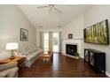 Bright living room with vaulted ceilings, cozy fireplace, hardwood floors and sliding glass doors for natural light at 5513 Edgebury Rd, Raleigh, NC 27613