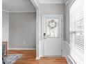 Bright entryway featuring wood floors, wainscoting, and a front door with decorative glass at 734 Hornchurch Loop, Cary, NC 27519
