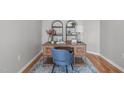 Stylish home office space with wood desk, shelves, blue chair, and area rug at 734 Hornchurch Loop, Cary, NC 27519
