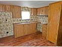 Galley kitchen featuring wood cabinetry, laminate countertops, and linoleum flooring at 8025 Hebron Church Rd, Garner, NC 27529