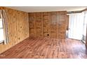 View of the wood paneled living room with laminate flooring at 8025 Hebron Church Rd, Garner, NC 27529