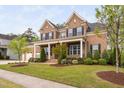 Charming brick home featuring a manicured lawn with tasteful landscaping and covered front porch at 832 Mountain Vista Ln, Cary, NC 27519
