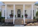 Inviting front porch with brick steps, decorative chairs, and black front door at 862 Legacy Falls S Dr, Chapel Hill, NC 27517