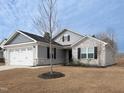 Charming single-story home with gray siding, stone accents, and well-maintained front yard at 8630 Kenridge Ln, Fuquay Varina, NC 27526