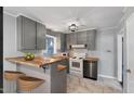 Updated kitchen with sleek gray cabinets, modern appliances, breakfast bar, and trendy tile flooring at 902 Long Ave, Garner, NC 27529