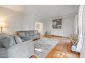 Bright living room with hardwood floors, gray couches, and a decorative wall at 902 Loop Rd, Clayton, NC 27527