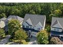 Aerial view of a two-story home with a dark roof, surrounded by lush trees in a neighborhood at 957 Vandalia Dr, Cary, NC 27519