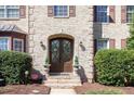 Elegant arched double front doors with sidelights and brick facade create a welcoming entrance at 10841 Round Brook Cir, Raleigh, NC 27617