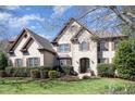 A charming two-story brick home showcases an arched entryway, manicured landscaping, and a well-kept lawn at 10841 Round Brook Cir, Raleigh, NC 27617