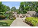 Charming home featuring a well-manicured lawn, mature trees, and a private driveway leading to a two-car garage at 12117 Cliffside Cir, Raleigh, NC 27614