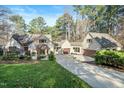 Charming home featuring a well-manicured lawn, mature trees, and a private driveway leading to a two-car garage at 12117 Cliffside Cir, Raleigh, NC 27614