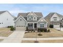 An aerial view of this charming two-story home showcases its manicured lawn, attached garage, and inviting curb appeal at 1212 Stonemill Falls Dr, Wake Forest, NC 27587