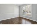 Neutral bedroom with large window providing natural light and hardwood floors, perfect for relaxing at 12404 Brandon Hall Dr, Raleigh, NC 27614
