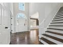 Bright foyer with soaring ceilings, elegant staircase, hardwood floors, and plenty of natural light at 12404 Brandon Hall Dr, Raleigh, NC 27614