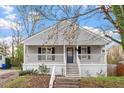 Attractive home featuring gray siding, black shutters, a welcoming porch, and well-maintained landscaping at 1304 Drew St, Durham, NC 27701