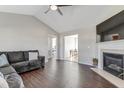 Spacious living room with dark wood floors, vaulted ceiling, fireplace, and a view into an adjacent dining area at 131 Woodglen Dr, Clayton, NC 27527