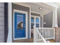 Inviting front porch with charming details, including a blue door and white railing at 1312 Big Falls Dr, Wendell, NC 27591