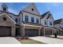 Stunning townhome showcasing brick and siding, a two-car garage, and manicured landscaping at 163 Periwinkle Pl, Clayton, NC 27527