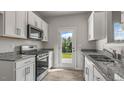 Bright kitchen with stainless appliances, gray countertops, and backyard views at 176 Starlight St, Sanford, NC 27330