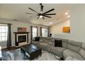 Bright living room with fireplace, hardwood floors, and vaulted ceiling with fan at 1930 Maple Sugar Ln, Fuquay Varina, NC 27526