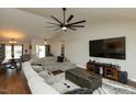 Open-concept living room with a large sectional, hardwood floors, and a view of the dining area at 1930 Maple Sugar Ln, Fuquay Varina, NC 27526