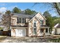 Beautiful two-story home with an attached garage, manicured lawn, and charming front porch perfect for relaxing at 209 Tullich Way, Holly Springs, NC 27540