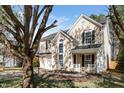 Inviting two-story home showcasing a well-kept lawn, attached garage, and a cozy front porch adorned with a festive wreath at 209 Tullich Way, Holly Springs, NC 27540