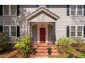A charming front porch with brick steps, black iron railings, and planters at 212 W University Dr, Chapel Hill, NC 27516