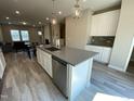 Bright kitchen showcasing stainless steel appliances, a large island with seating, and wood-look floors at 219 Adobe Pl, Cary, NC 27519