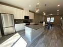 Modern kitchen features stainless steel appliances, a large island, and white cabinets at 219 Adobe Pl, Cary, NC 27519