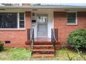 Inviting front entrance with classic brick steps and black railing at 2246 Hillandale Rd, Durham, NC 27705
