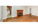 Spacious living room featuring original hardwood floors and a charming fireplace at 2246 Hillandale Rd, Durham, NC 27705
