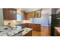 Modern kitchen with granite counters, stainless appliances, and wooden cabinets at 2429 Falls River Ave, Raleigh, NC 27614