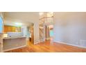 Spacious living room with hardwood floors, staircase and breakfast bar open to kitchen at 2429 Falls River Ave, Raleigh, NC 27614