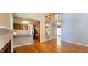Bright living room featuring hardwood floors, natural light, staircase, and kitchen access at 2429 Falls River Ave, Raleigh, NC 27614