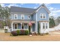 Charming two-story home with blue siding, a welcoming porch, and manicured landscaping at 2601 Forestville Rd, Wake Forest, NC 27587