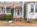 Inviting front porch with brick steps, decorative columns, and an American flag on display at 2601 Forestville Rd, Wake Forest, NC 27587