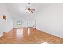 Open-concept living room with hardwood floors, a ceiling fan, and large windows providing ample light at 2776 Jordan Ct, Creedmoor, NC 27522