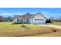 Attractive single-story home with white siding, a blue front door, and a two car garage at 28 Sandcastle Ln, Four Oaks, NC 27524