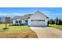 Charming one-story home with white siding, a bright blue door, and a spacious two car garage at 28 Sandcastle Ln, Four Oaks, NC 27524