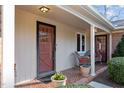 Inviting front porch featuring neutral siding, brick flooring, and decorative potted plants at 3001 Blanche Dr, Burlington, NC 27215