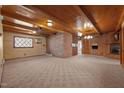 Large living room with carpeted floor, brick walls, and wood paneled ceilings at 3001 Blanche Dr, Burlington, NC 27215