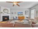 Cozy living room featuring a fireplace, ceiling fan, and comfortable seating arrangement at 301 Coral Creek Ln, Morrisville, NC 27560
