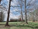 Exterior view of home on large lot with mature trees, red brick exterior, and a brick chimney at 3015 Nc Hwy 87 South, Graham, NC 27253