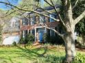Beautiful two-story brick home with a blue front door, black shutters, and a well-manicured lawn at 307 Kellyridge Dr, Apex, NC 27502